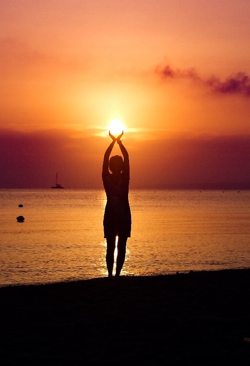 Afbeelding zonsondergang met persoon met zon in handen